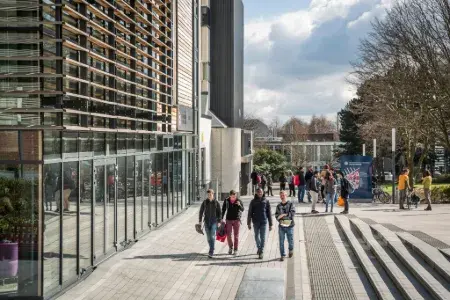 A group of students walk past the Murray Library on the King's Buildings campus on a sunny day. The image is displayed in landscape orientation with 450x300 pixel dimensions.