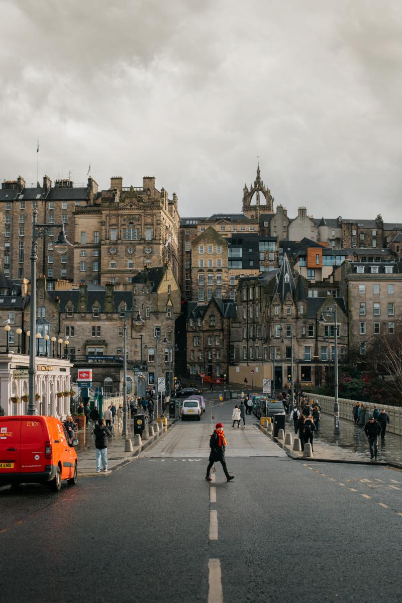 A view from Princes Street looking across Waverley Bridge towards Edinburgh Old Town. The image is displayed in landscape orientation, taking up the full width of the page with no cropping of the original image.